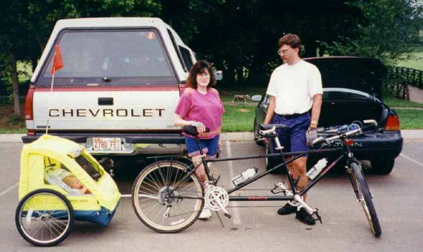 Foto of Lindal and Robertl, standing next to Tandem Bike.   Ryanl is in the trailer.