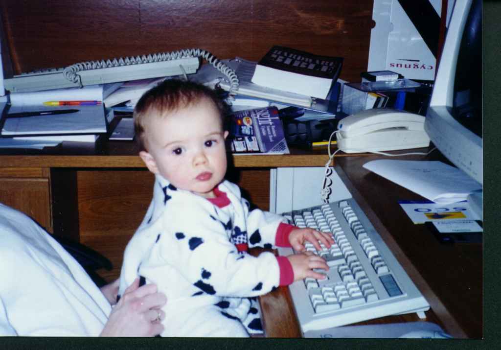 Foto of Ryanl, at about age one, sitting at the keyboard.
